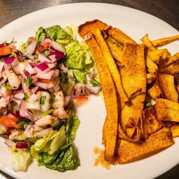Shrimp ceviche with red onions, tomatoes, and cilantro, served with crispy plantain chips.